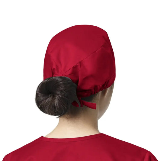 Femme portant un calot médical rouge WonderWink, facile à entretenir et éviter les contaminations