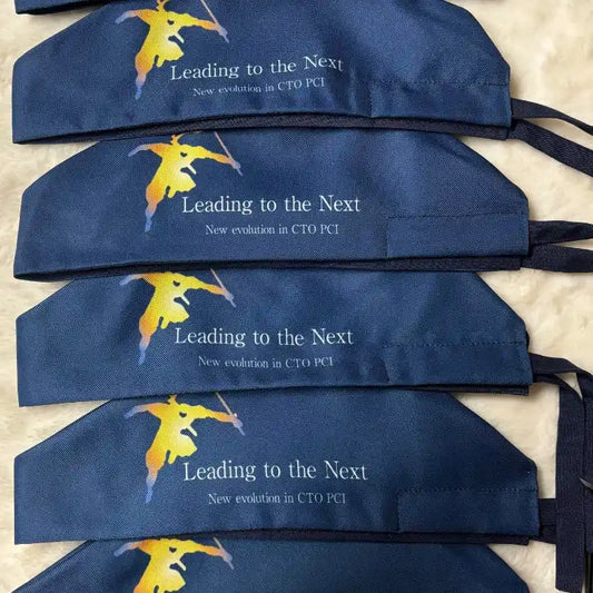 Des bonnets de chirurgie bleu marine avec un logo de figure jaune et le texte 'Menant au Suivant'.