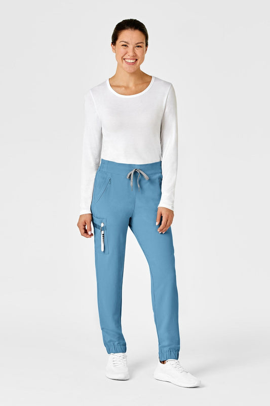 Femme en chemise blanche et pantalon bleu coupe moderne avec poches classiques