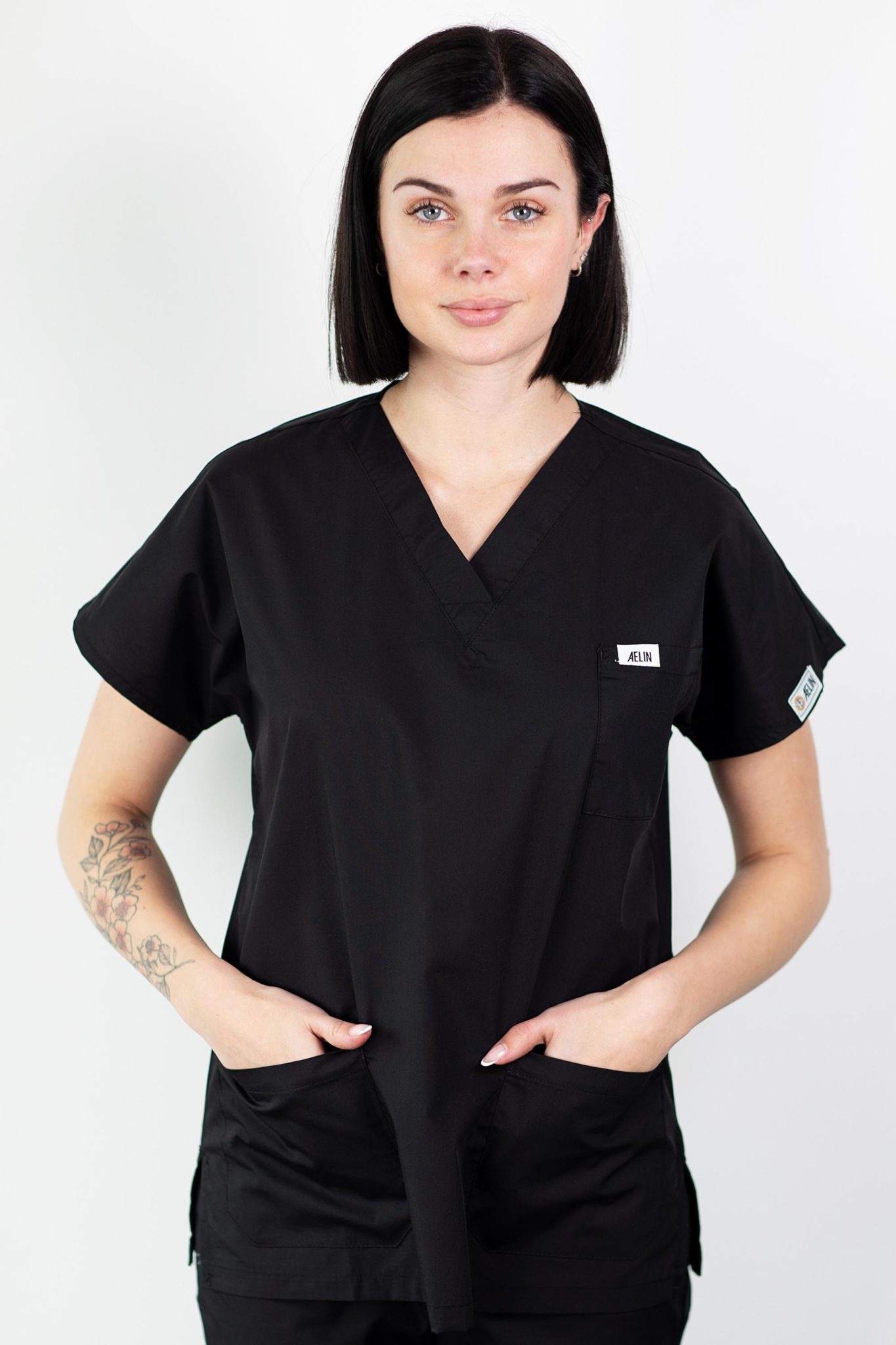 Femme en tunique médicale noire à manches courtes, élégante et confortable