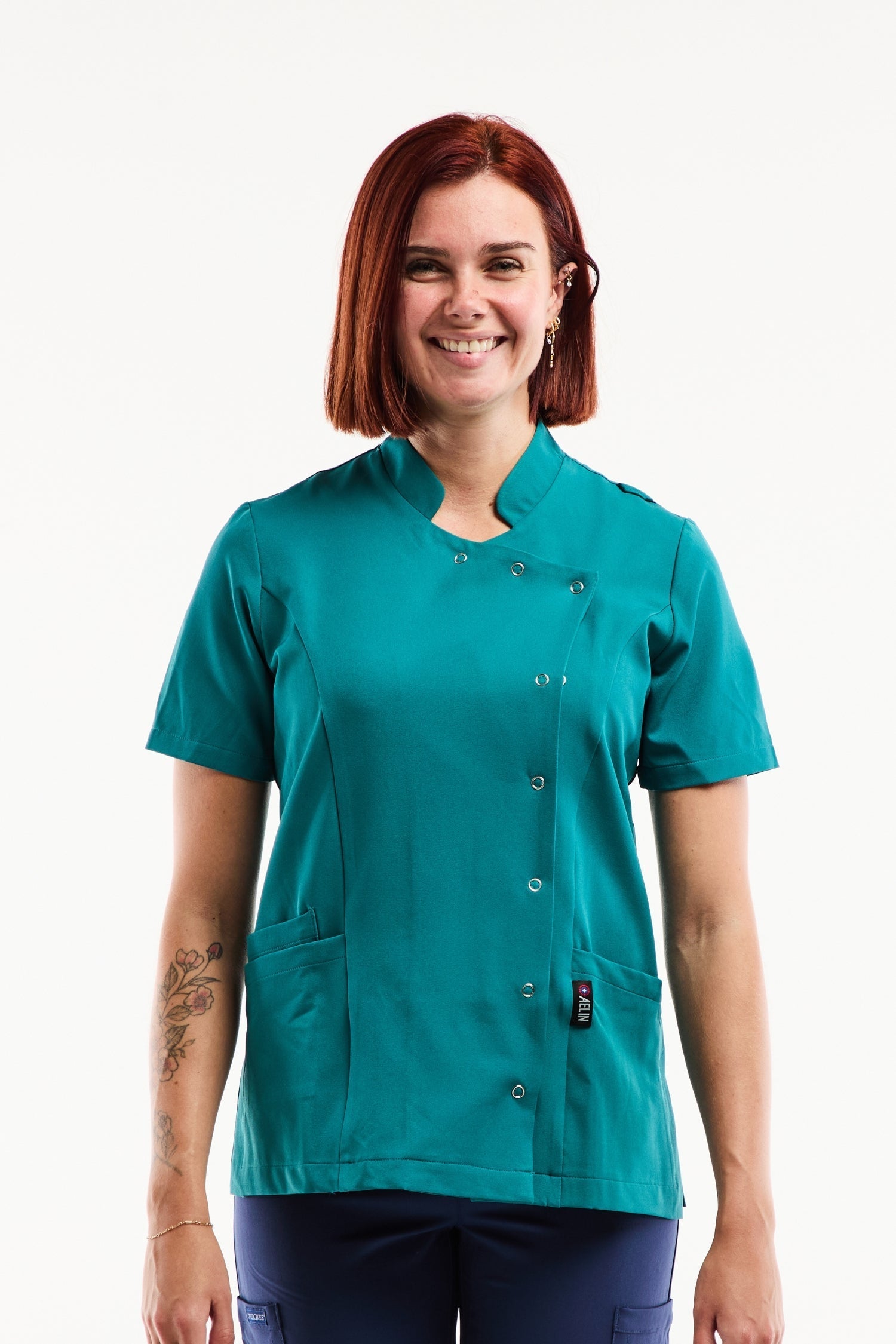 Blouse médicale femme Aurelia en bleu turquoise avec col officier et asymétrique à pressions