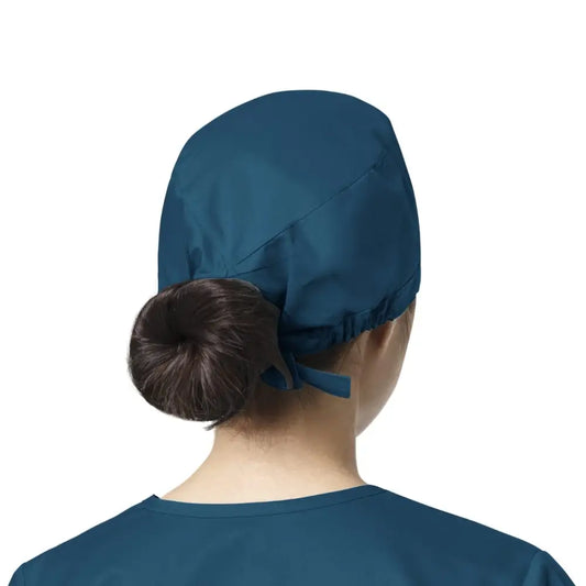 Femme portant un calot médical WonderWink bleu Caraibes facile à entretenir contre contaminations