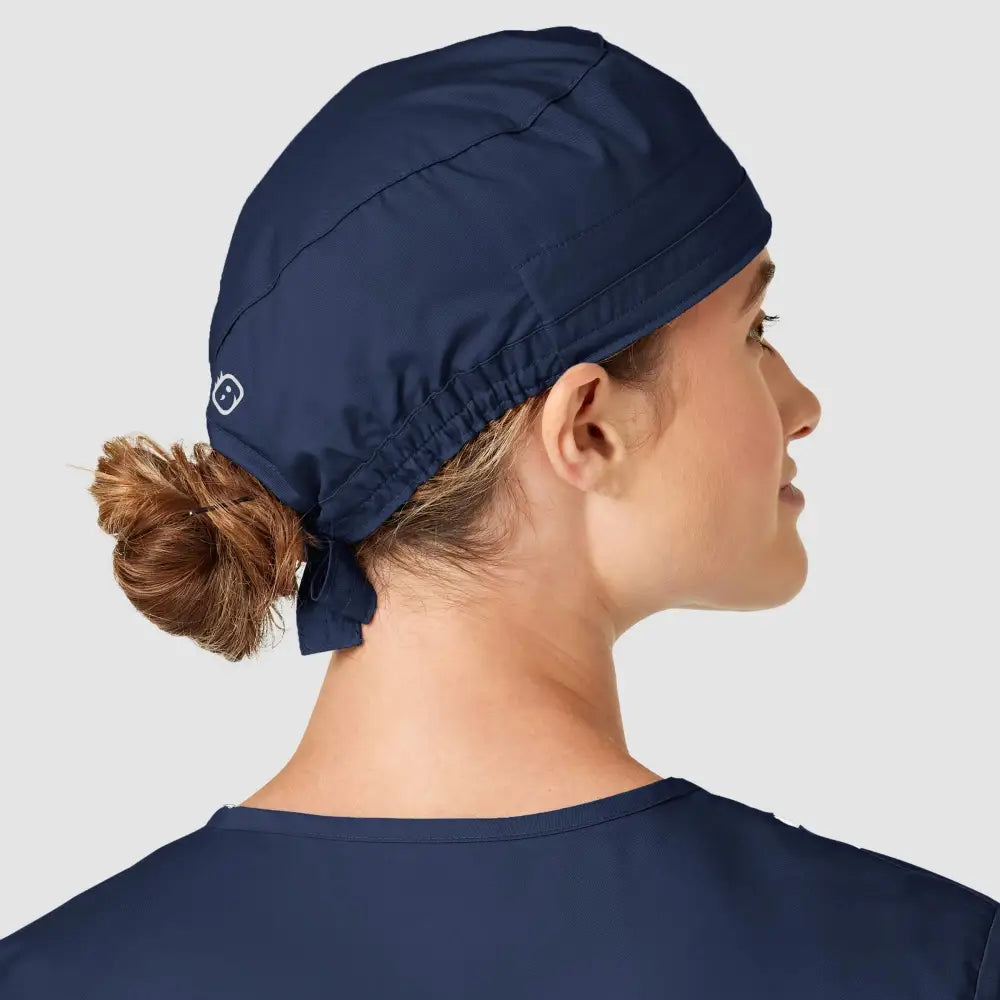 Dos d’une femme avec calot médical bleu marine WonderWink, facile à entretenir contre contaminations