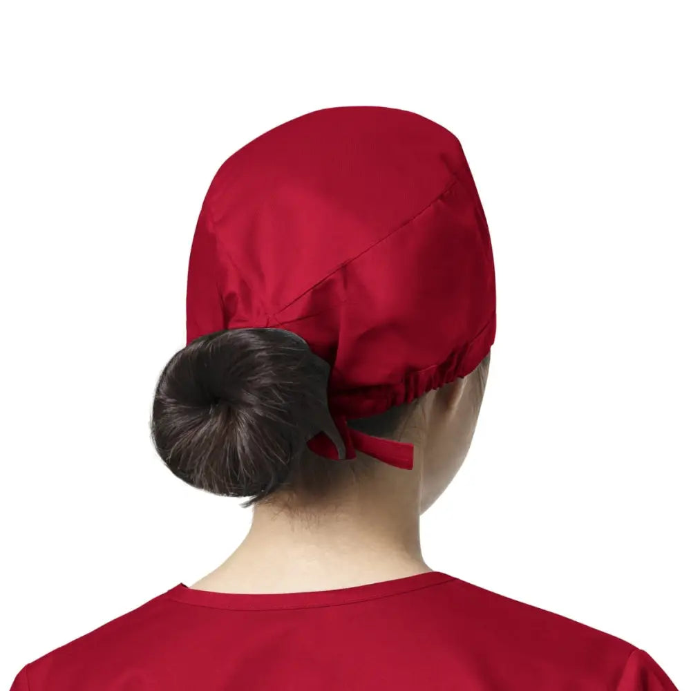 Femme portant un calot médical rouge WonderWink, facile à entretenir et éviter les contaminations
