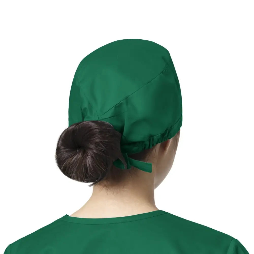 Femme portant un calot médical WonderWink vert, facile à entretenir contre les contaminations lors