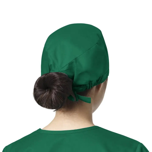 Femme portant un calot médical WonderWink vert, facile à entretenir contre les contaminations lors