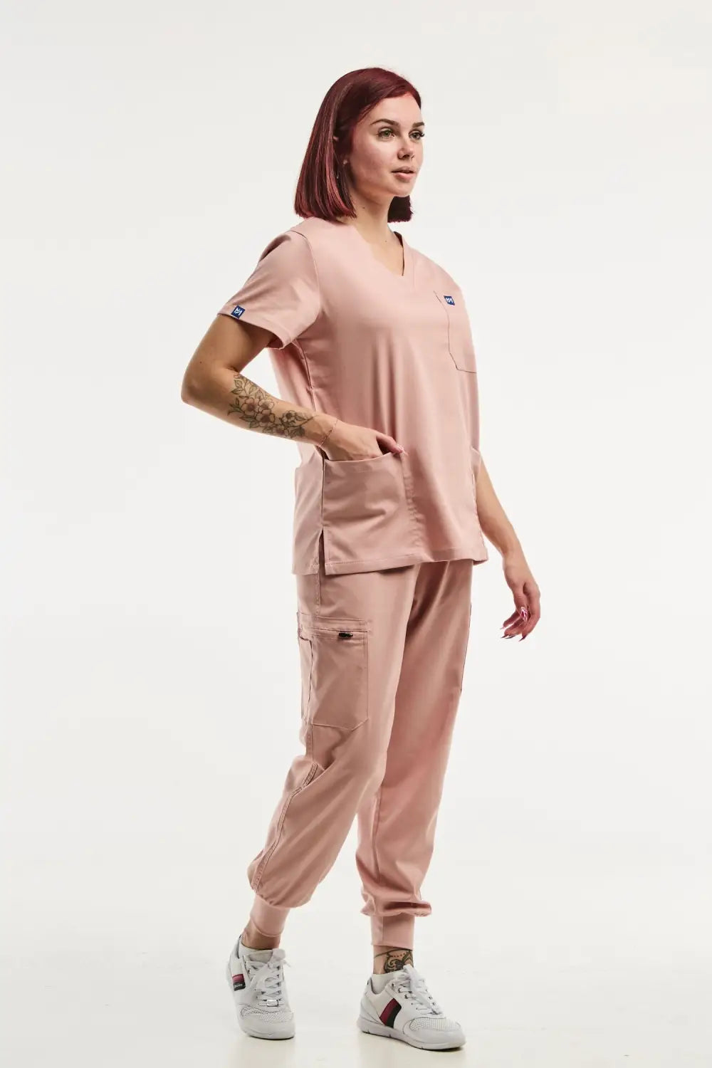 Femme portant la EMMA Jogger en tenue médicale rose clair, parfaitement adaptée