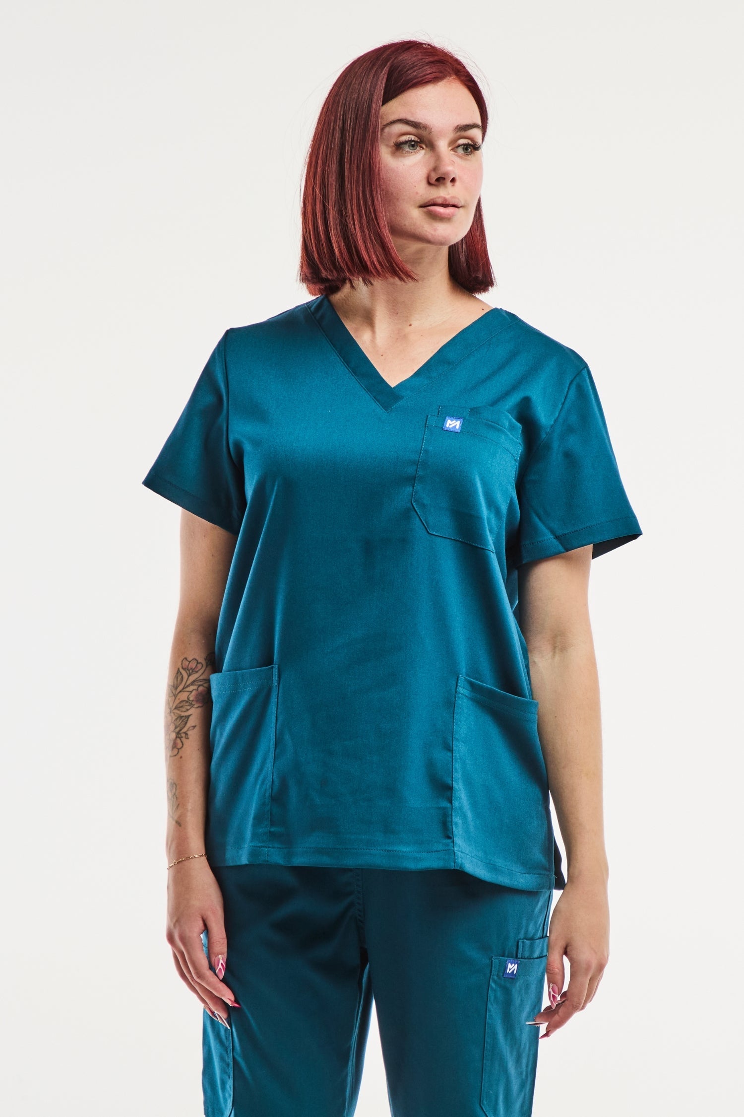 Femme portant EMMA tunique médicale col turquoise, vêtement professionnel femme