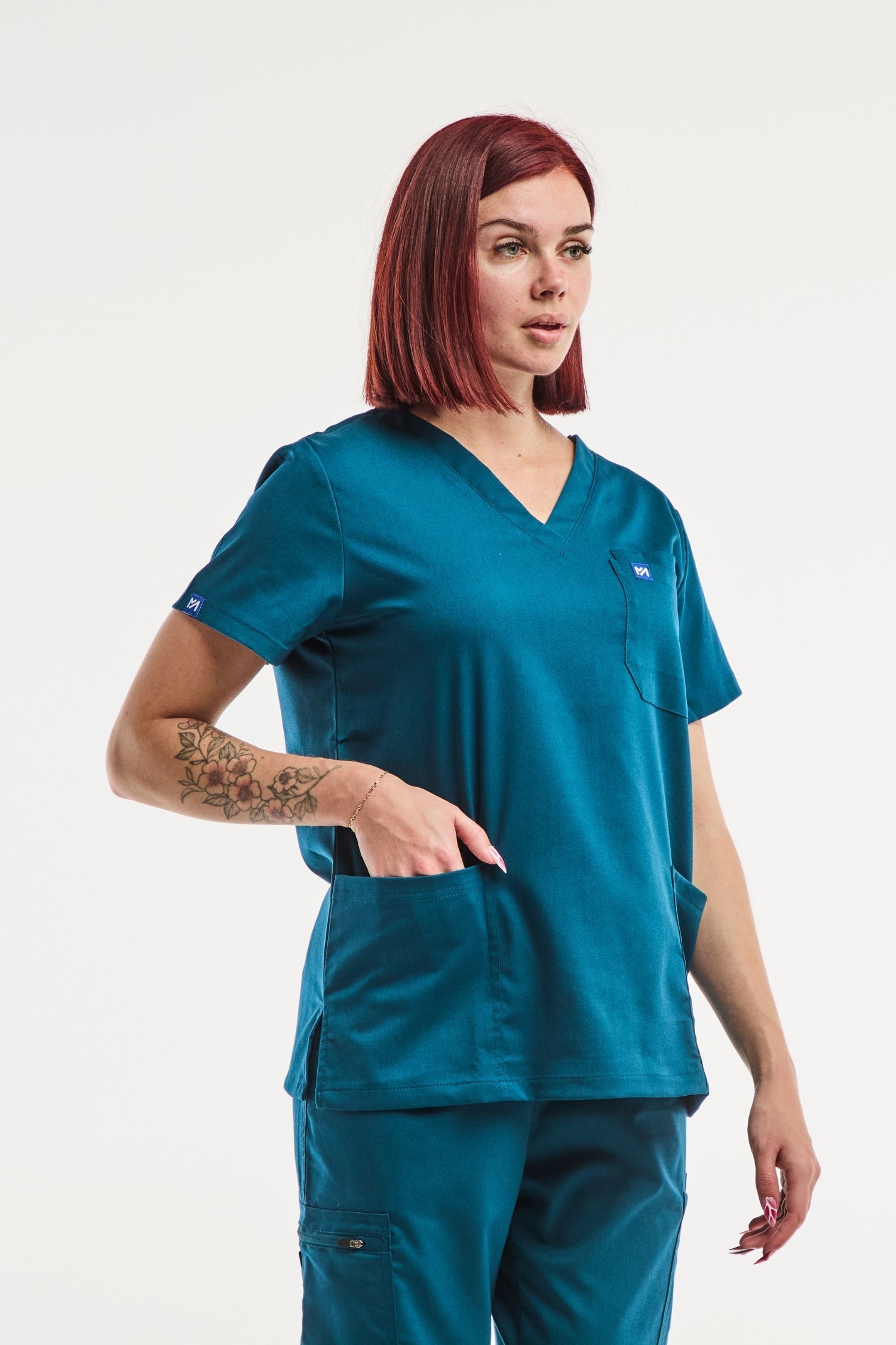 Image d’une tunique médicale femme EMMA turquoise avec col en V et poches