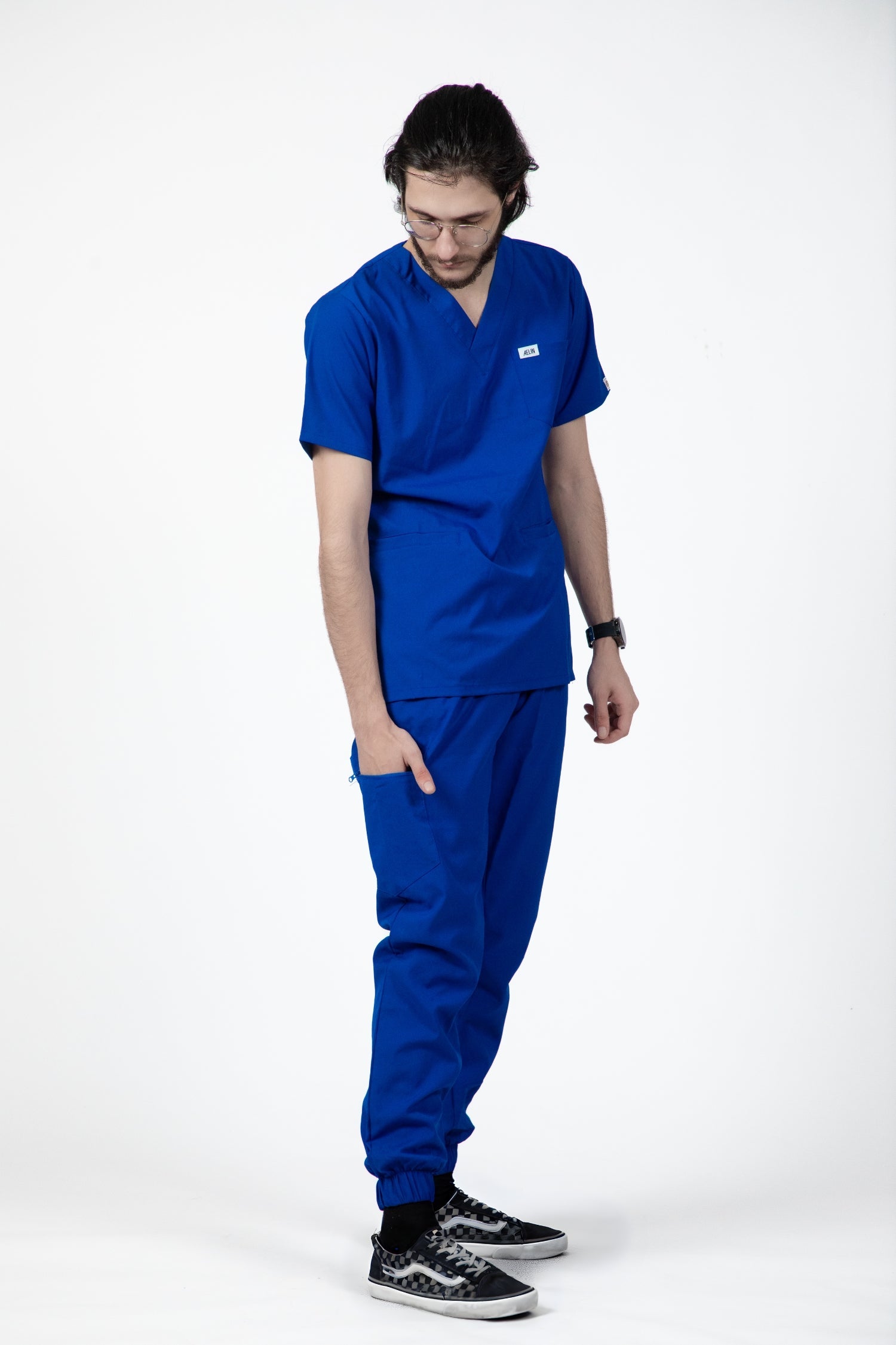 Homme portant un pantalon médical bleu royal slimfit, tenues médicales modernes et élégantes