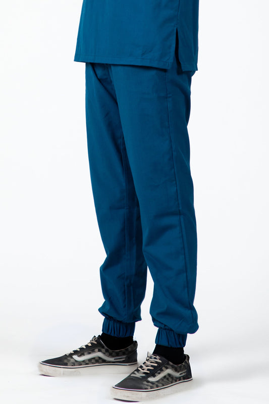 Homme en costume bleu turquoise, pantalon médical slimfit avec chaussures noires