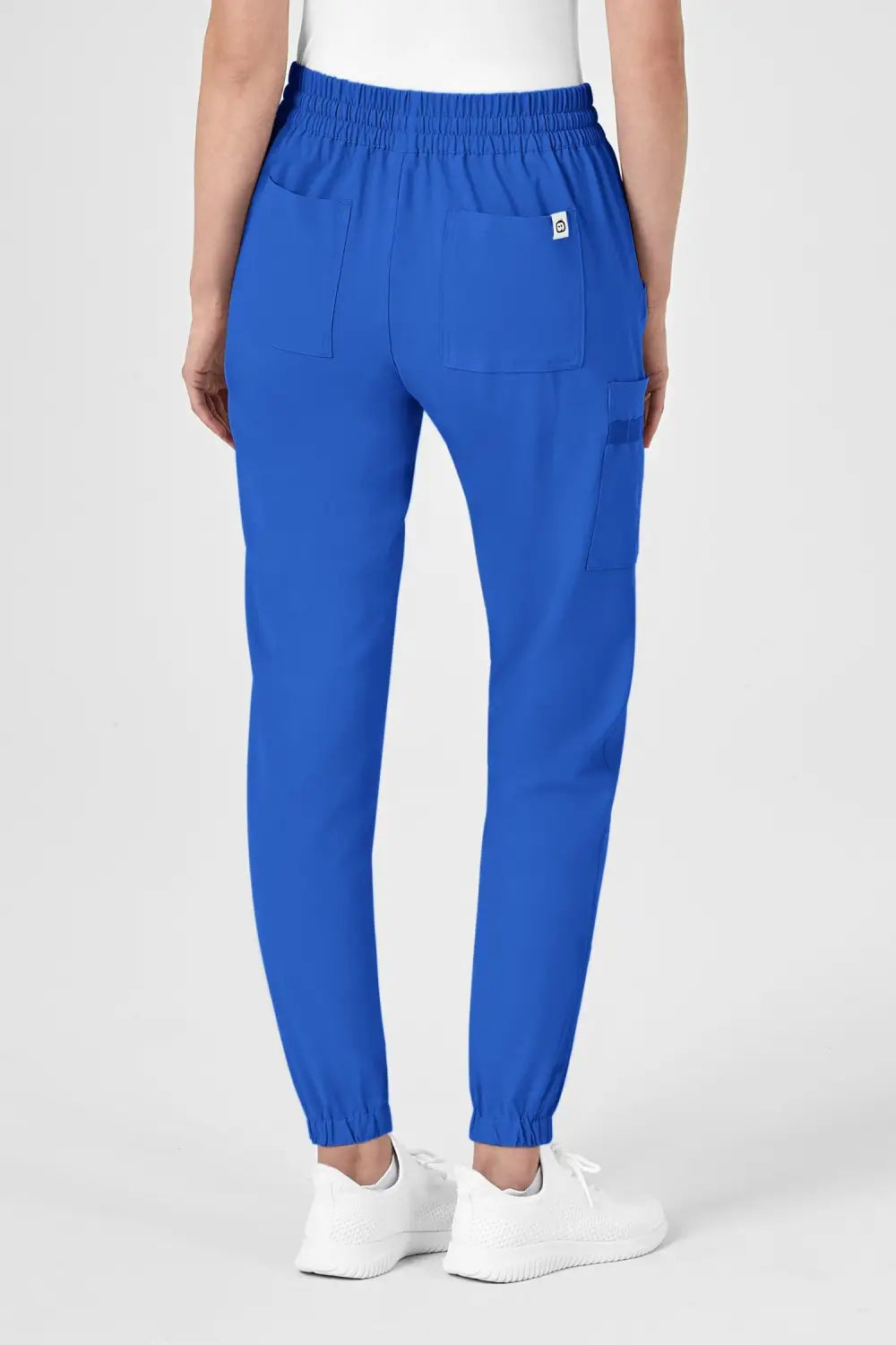 Une femme portant un pantalon médical bleu royal avec poches classiques et coupe moderne
