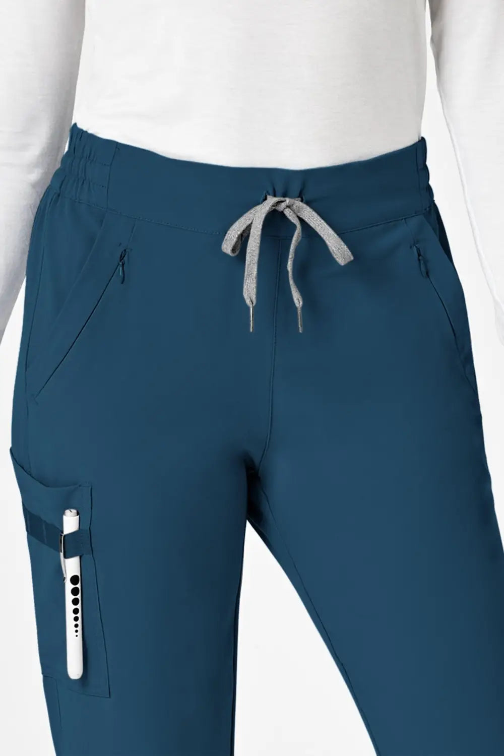 Vue de dos d’une femme en blouse blanche et pantalon cargo bleu turquoise à coupe moderne