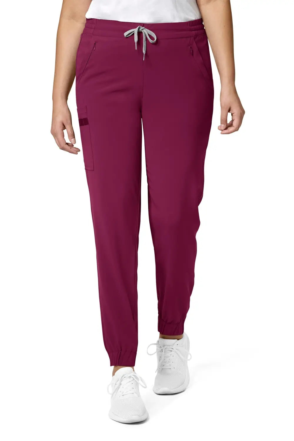 Une femme portant des pantalons médicaux bordeaux avec coupe moderne et poches cargo