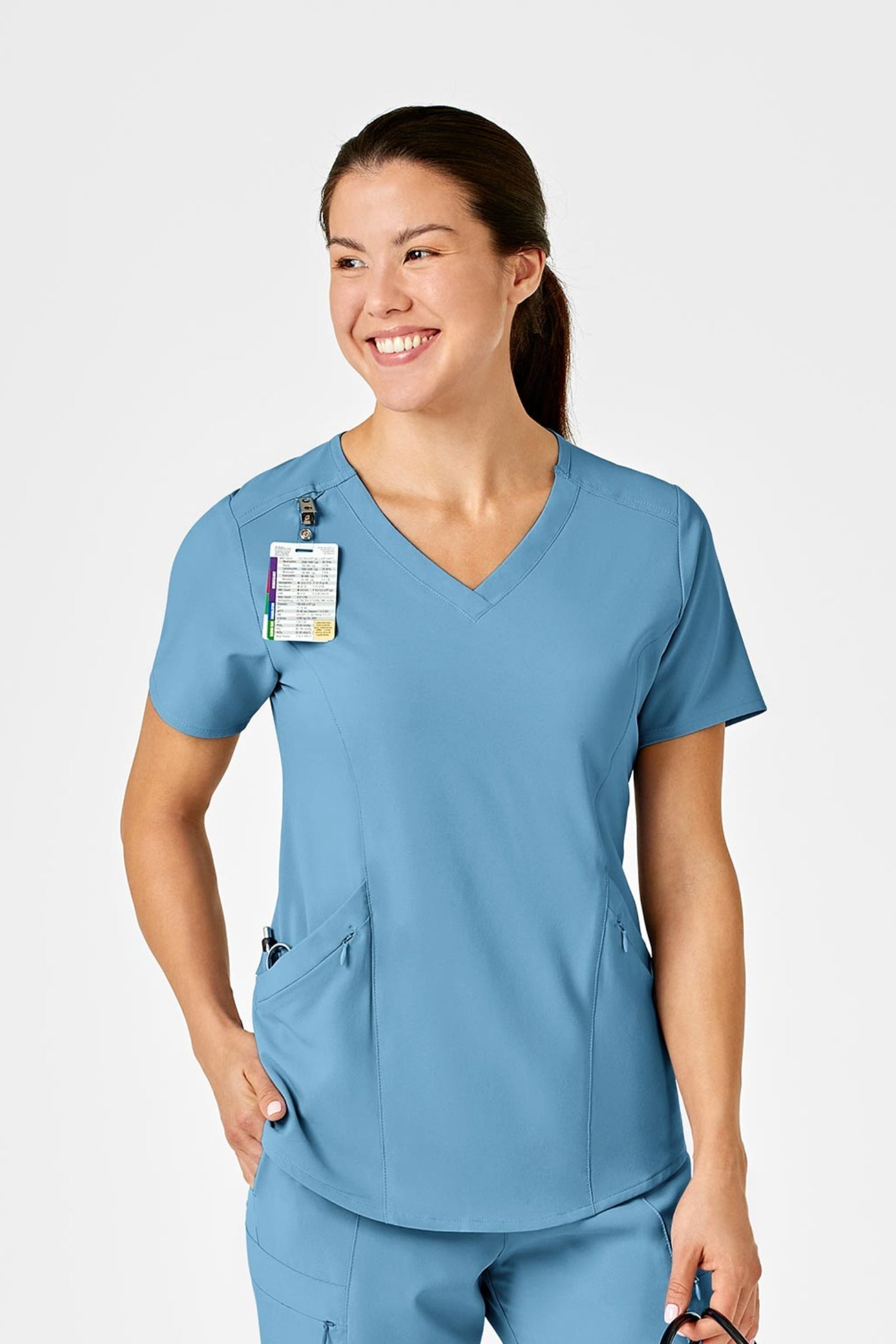 Femme en tenue médicale bleue en polyester spandex, souriant et tenant un stéthoscope