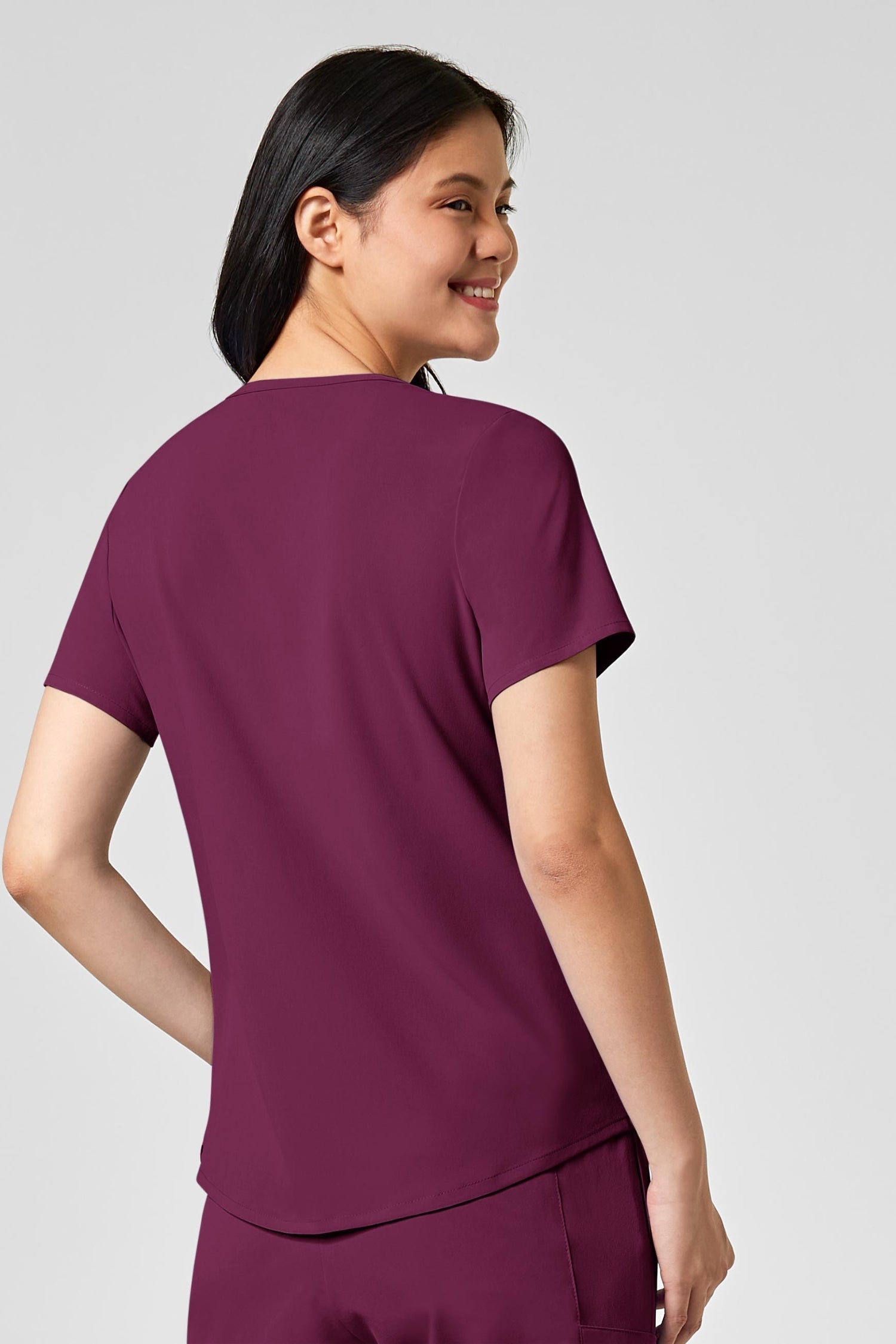 Femme en tenue médicale bordeaux avec poches à fermeture, polyester spandex