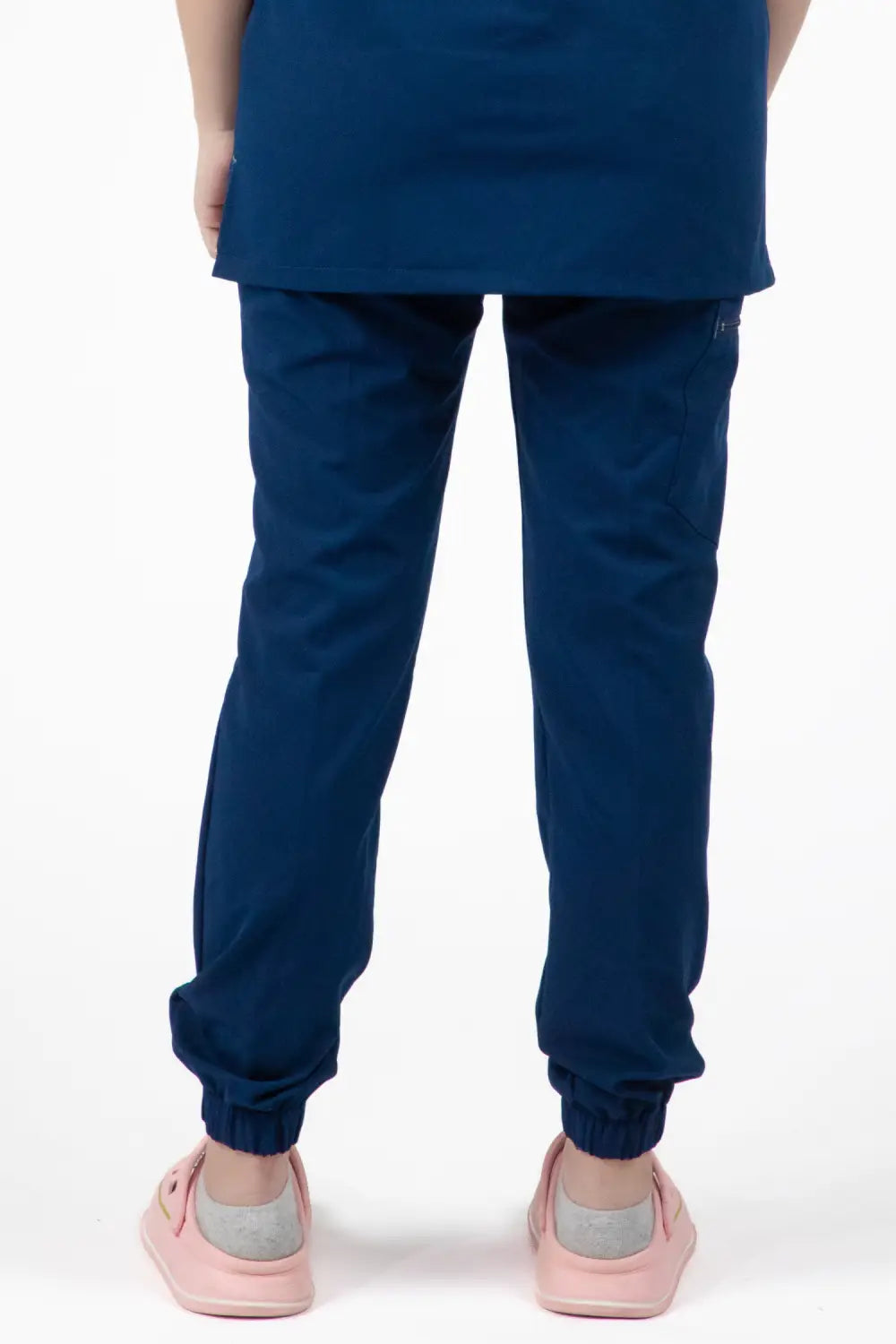 Petite fille en pantalon médical bleu de la collection Slimfit NEW, chaussures roses