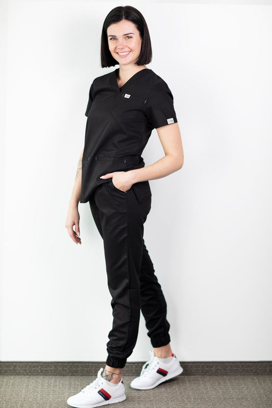 Une femme en top noir et pantalon noir portant le pantalon médical Slimfit NEW – Pantalon médical – Noir