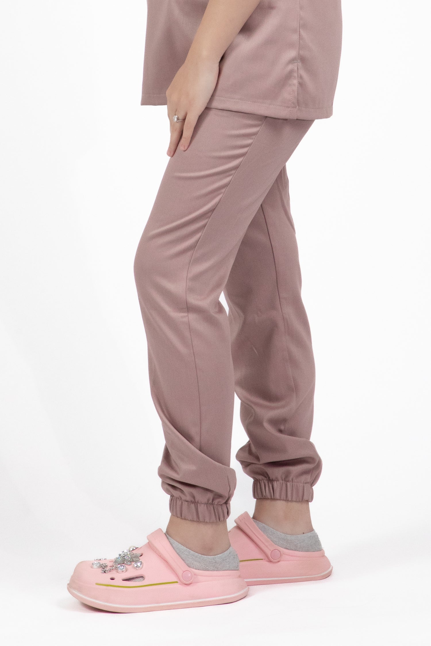 Une femme portant un pantalon médical Slimfit NEW rose et un t-shirt blanc