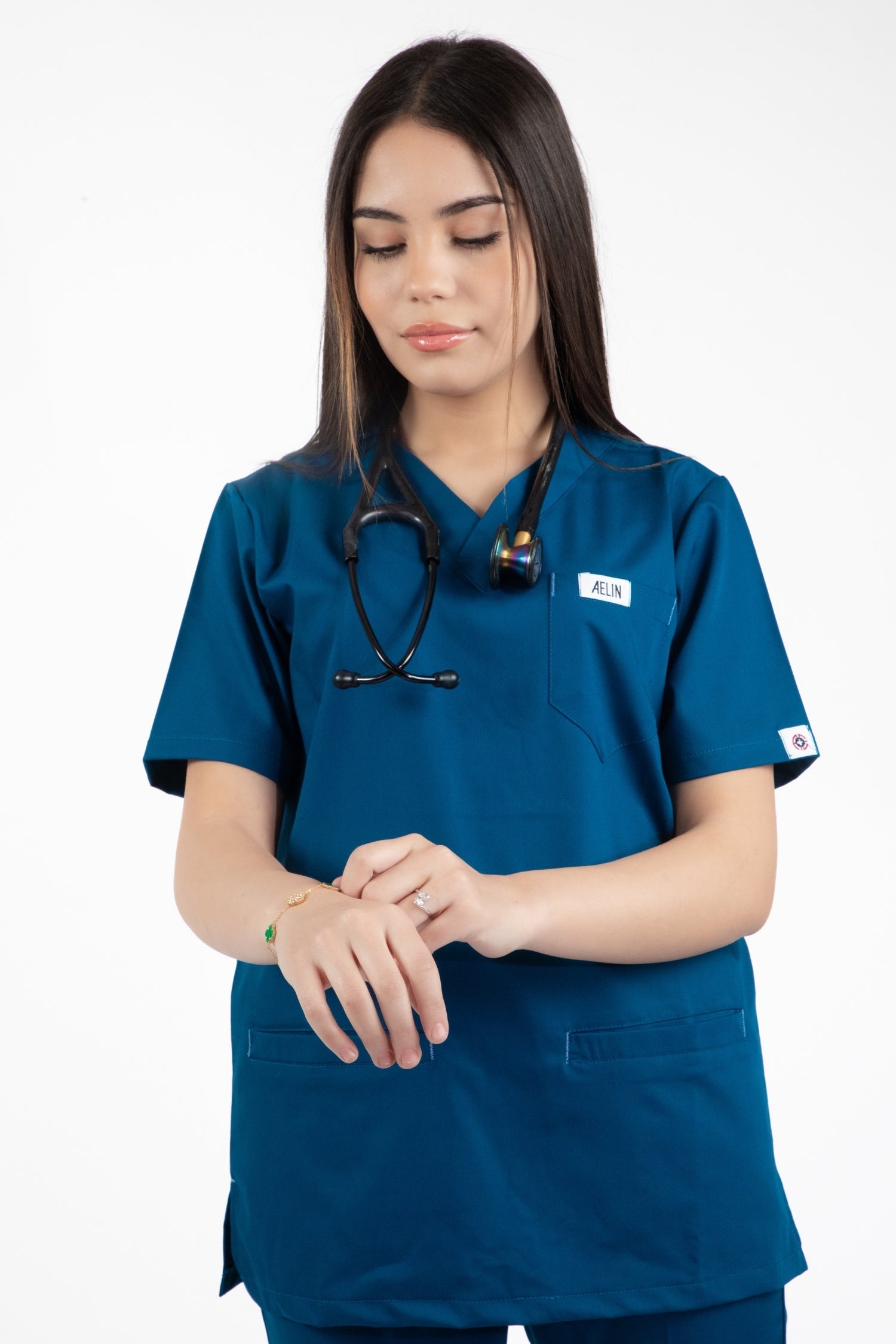 Une femme en uniforme médical turquoise scrubs ses mains avec une blouse et un pantalon