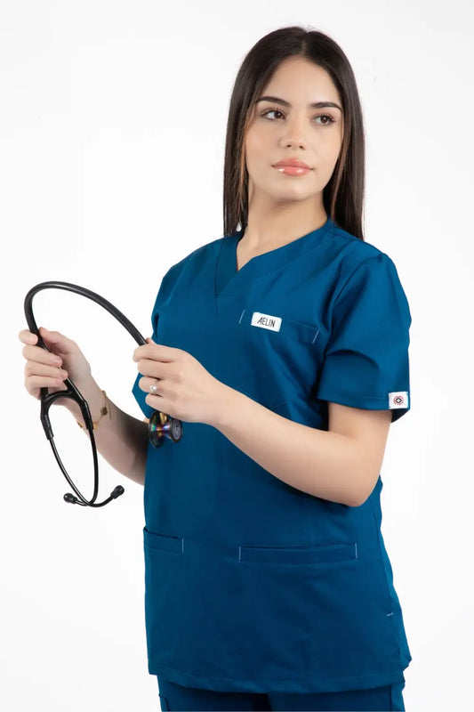 Une femme en scrubs tenant un stéthoscope avec la Slimfit NEW – Tunique médicale – Bleu turquoise