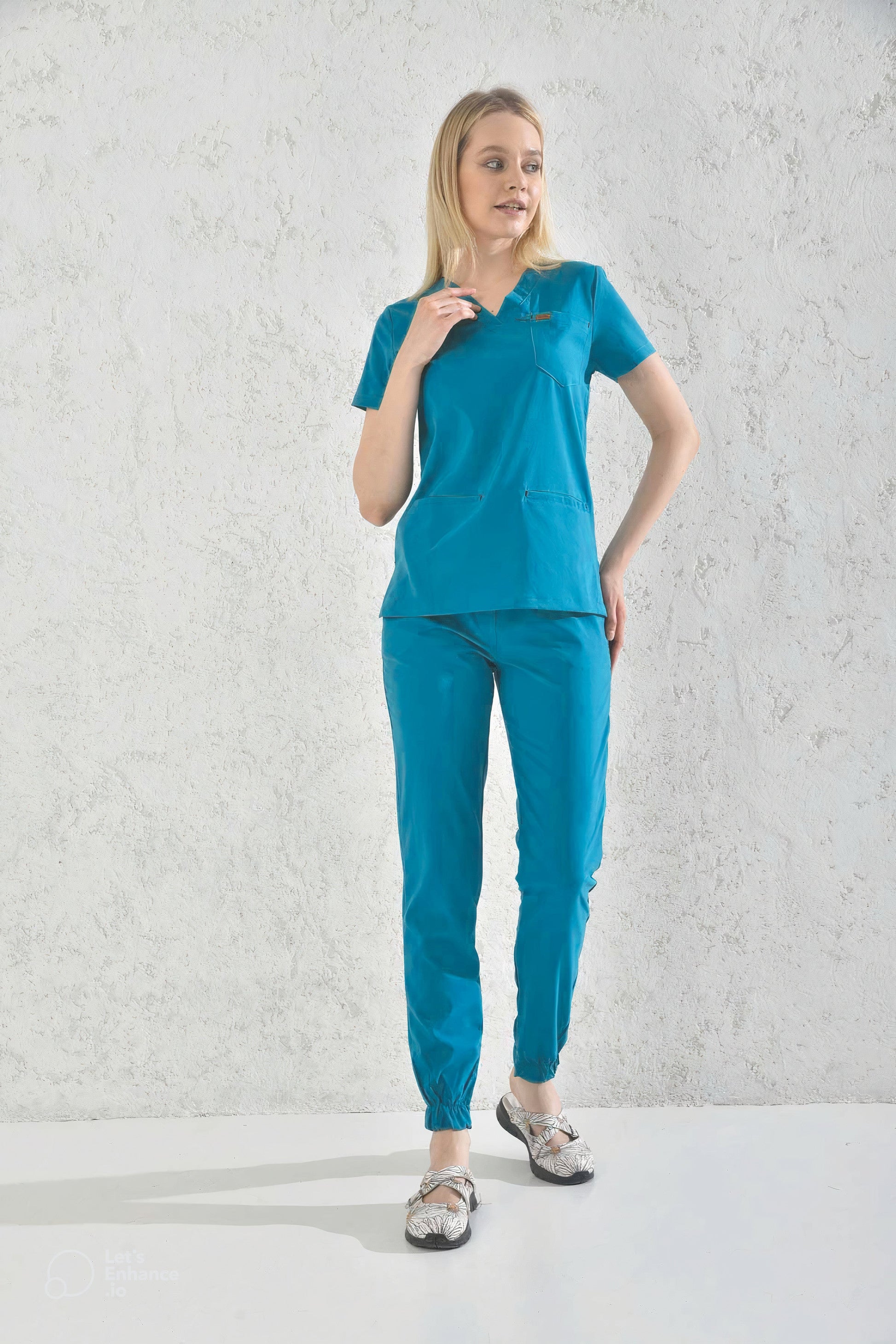 Une femme en pantalon médical bleu cyan Slimfit, uniformes et tenues médicales modernes