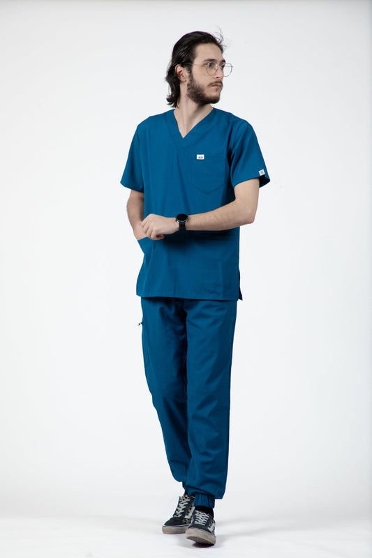 Homme en uniforme médical bleu turquoise, comprenant une blouse et un pantalon slimfit
