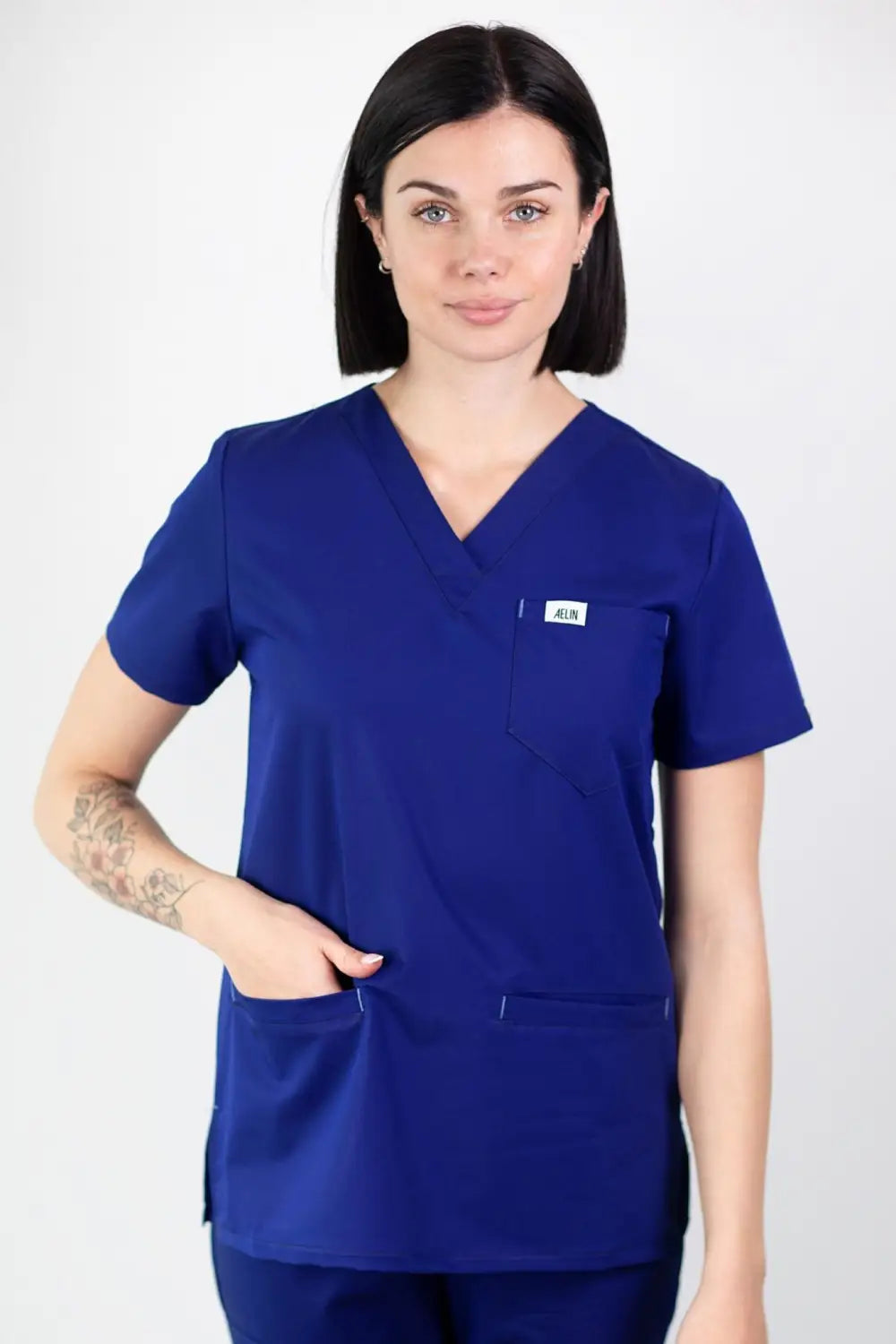 Femme portant tunique médicale bleu royal Slim fit; tenues médicales élégantes et confortables