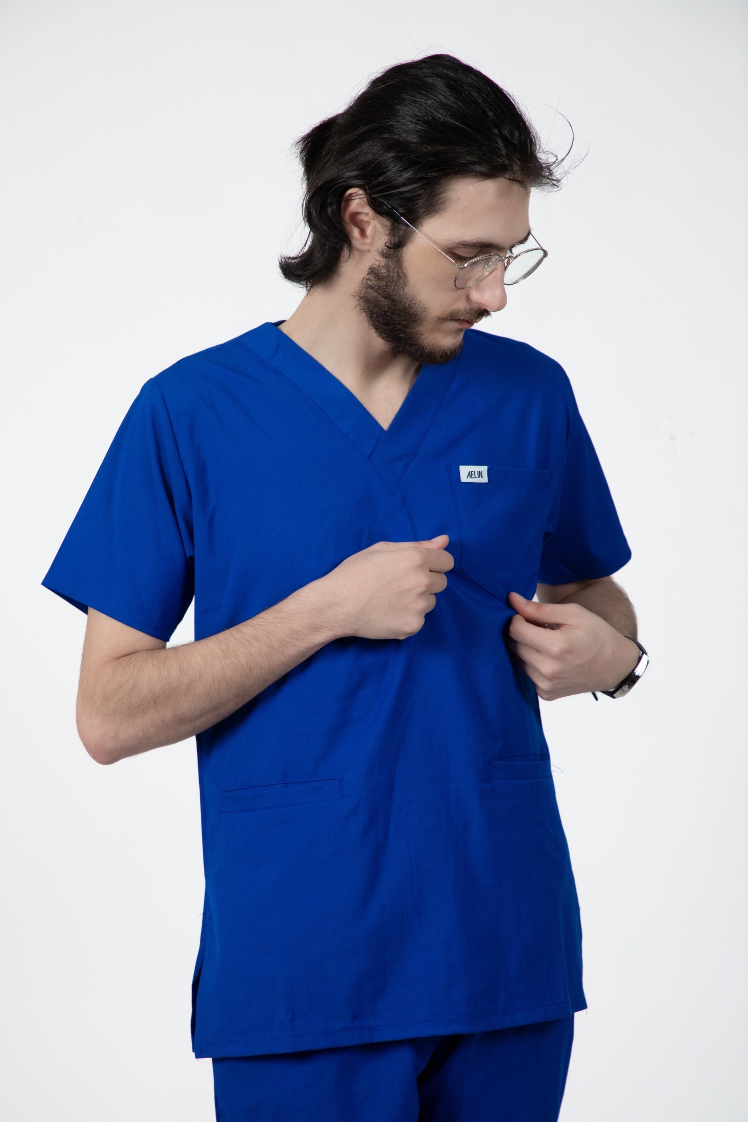 Un homme portant une tunique médicale bleu royal Slimfit parmi les tenues médicales
