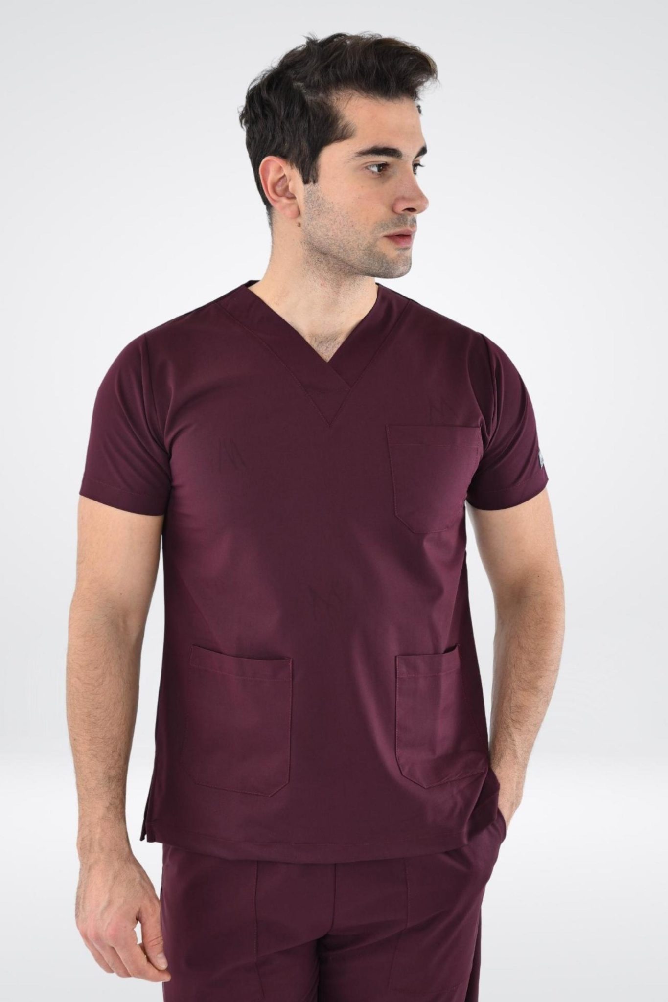 Un homme portant une tunique médicale bordeaux pour hommes, tenues médicales confort